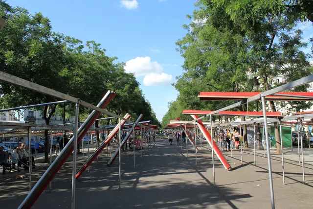 Longue rangée d’armatures de stands entre deux alignements d’arbres